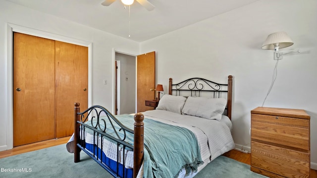 bedroom with a closet, a ceiling fan, and wood finished floors