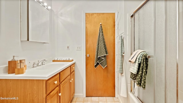 full bath featuring an enclosed shower, vanity, and tile patterned flooring