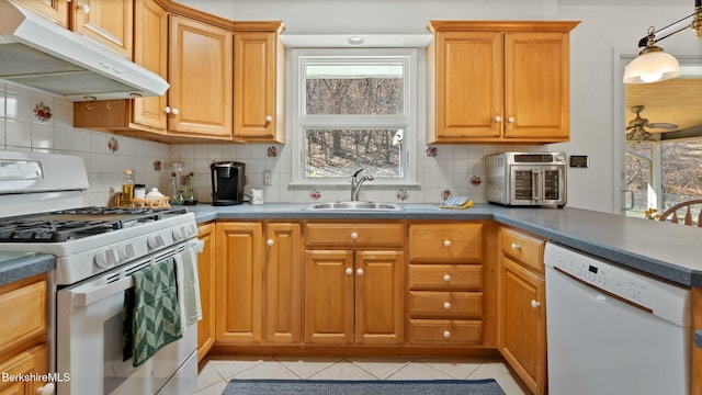 kitchen featuring light tile patterned floors, white appliances, under cabinet range hood, a sink, and decorative backsplash
