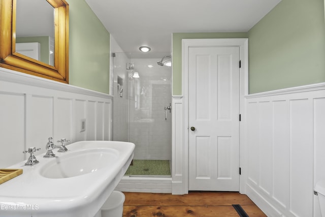 16 Glendale Middle Rd, Stockbridge, MA 01262 - full bathroom featuring a wainscoted wall, a stall shower, wood finished floors, a decorative wall, and a sink