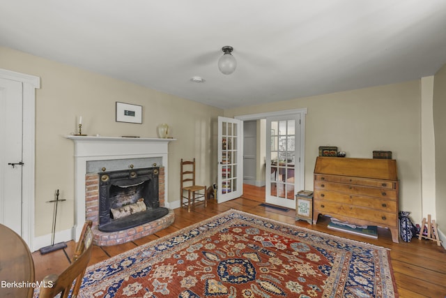 16 Glendale Middle Rd, Stockbridge, MA 01262 - living room with hardwood / wood-style flooring, french doors, a brick fireplace, and baseboards