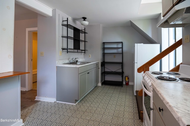 1057 Main St, Great Barrington, MA 01236 - kitchen with white electric stove, under cabinet range hood, a sink, light countertops, and gray cabinetry