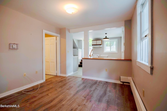 1057 Main St, Great Barrington, MA 01236 - unfurnished living room featuring wood finished floors, baseboards, and a baseboard radiator