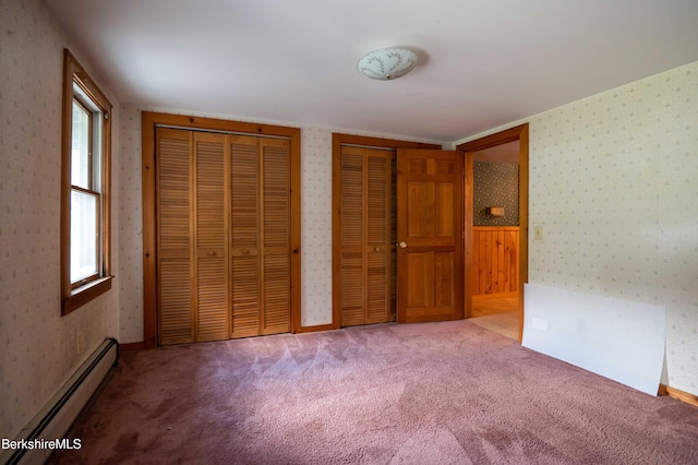 1057 Main St, Great Barrington, MA 01236 - unfurnished bedroom featuring a baseboard radiator, two closets, multiple windows, wallpapered walls, and carpet