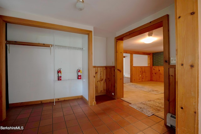1057 Main St, Great Barrington, MA 01236 - washroom with wooden walls, a baseboard radiator, a wainscoted wall, and tile patterned floors