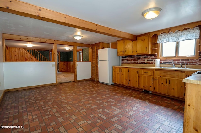 1057 Main St, Great Barrington, MA 01236 - kitchen with freestanding refrigerator, a sink, light countertops, brick patterned flooring, and wooden walls