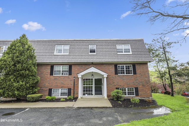 view of front of property with mansard roof and brick siding