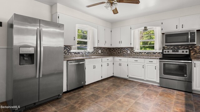 85 Wilson St, Pittsfield, MA 01201 - kitchen featuring appliances with stainless steel finishes, plenty of natural light, decorative backsplash, and white cabinets