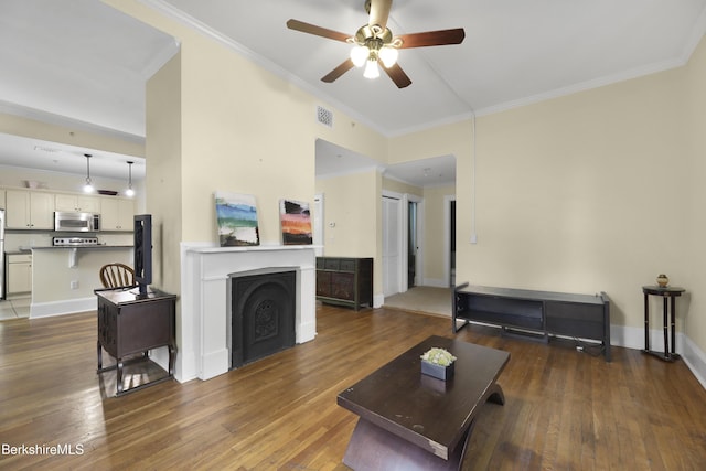 living room with ceiling fan, dark hardwood / wood-style flooring, and crown molding