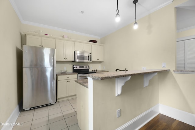 kitchen featuring pendant lighting, a kitchen breakfast bar, kitchen peninsula, appliances with stainless steel finishes, and white cabinetry