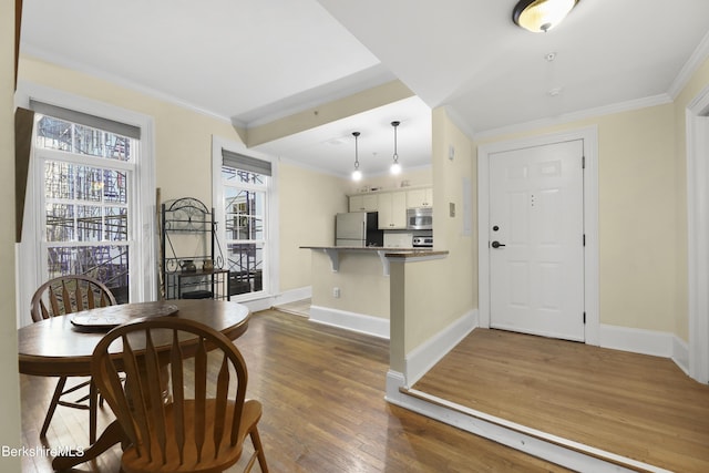 dining area with dark hardwood / wood-style floors and ornamental molding