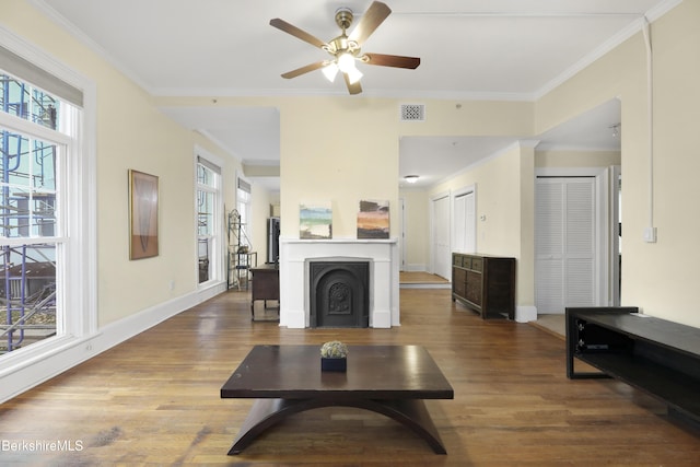 living room with wood-type flooring, ceiling fan, and crown molding