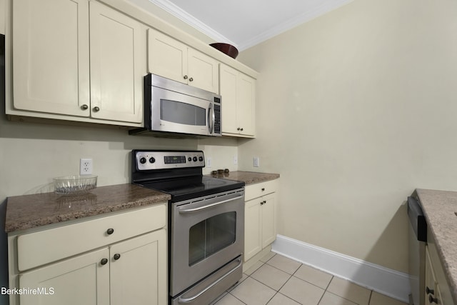 kitchen with ornamental molding, stainless steel appliances, light tile patterned floors, and dark stone counters