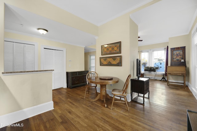 dining room with ornamental molding, ceiling fan, and dark wood-type flooring