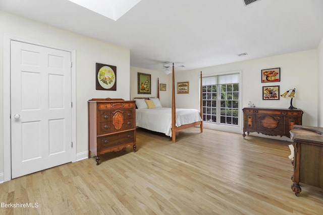 bedroom featuring light hardwood / wood-style floors and a skylight