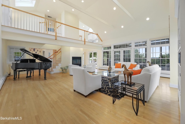 living room featuring a baseboard heating unit, high vaulted ceiling, and light hardwood / wood-style flooring