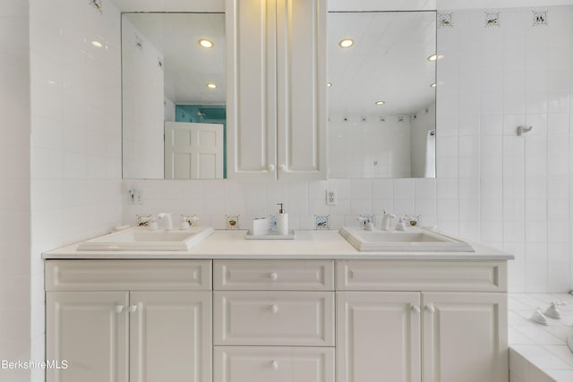 bathroom featuring vanity, tasteful backsplash, tile walls, and a bathing tub