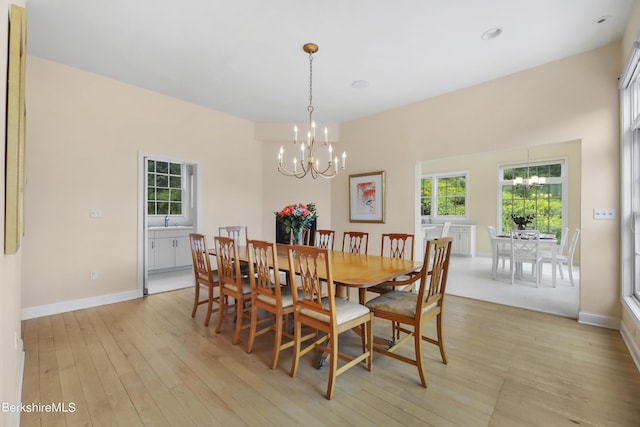 dining room with light hardwood / wood-style flooring and a chandelier