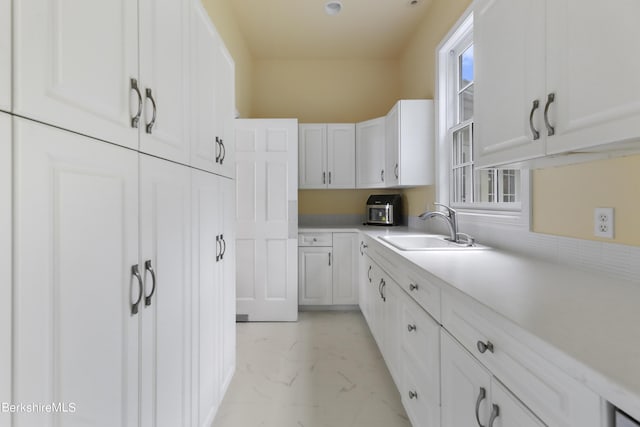 kitchen featuring white cabinets and sink