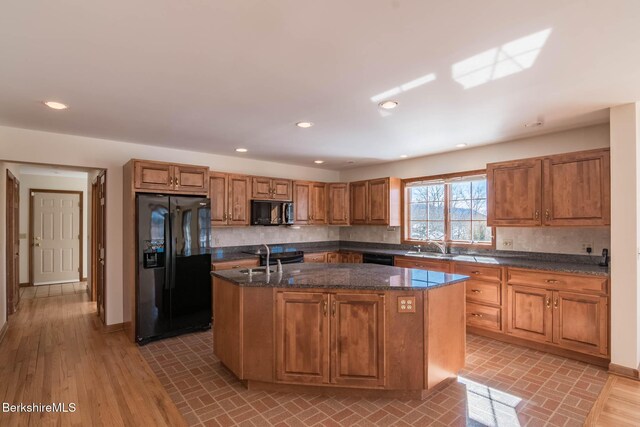 1166 Rannapo Rd, Sheffield, MA 01257 - kitchen with black appliances, an island with sink, backsplash, brown cabinets, and recessed lighting