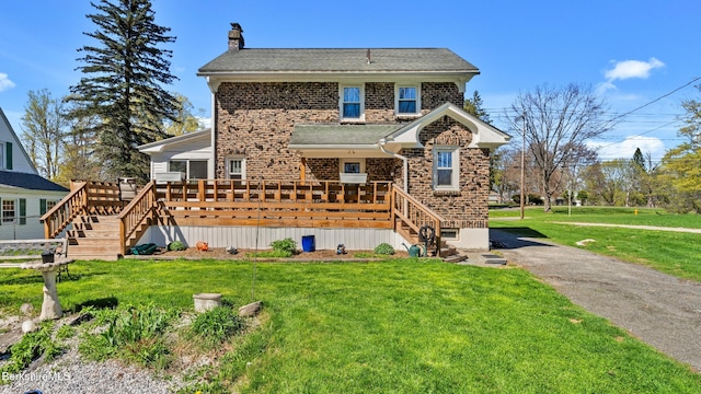 traditional-style home with a chimney, a front yard, roof with shingles, a deck, and stairway