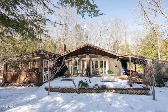 305 Shadow Ln, Sandisfield, MA 01255 - snow covered house with a chimney, a wooden deck, and a sunroom