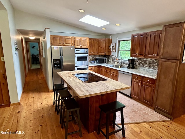 305 Shadow Ln, Sandisfield, MA 01255 - kitchen featuring appliances with stainless steel finishes, wood counters, a skylight, a breakfast bar area, and light wood finished floors