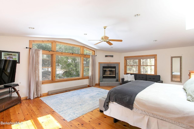 305 Shadow Ln, Sandisfield, MA 01255 - bedroom with baseboard heating, vaulted ceiling, hardwood / wood-style flooring, a glass covered fireplace, and ceiling fan