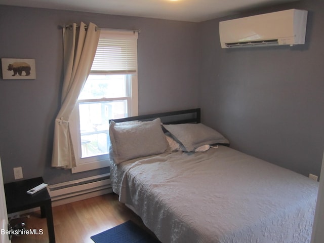 bedroom with an AC wall unit, light hardwood / wood-style flooring, and a baseboard radiator