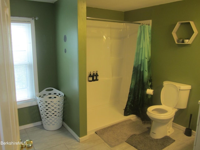 bathroom with tile patterned flooring, toilet, and walk in shower