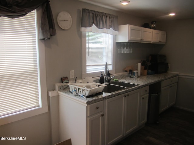 kitchen featuring white cabinetry, sink, and light stone countertops