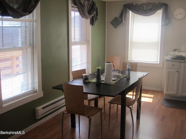 dining space with light wood-type flooring and baseboard heating