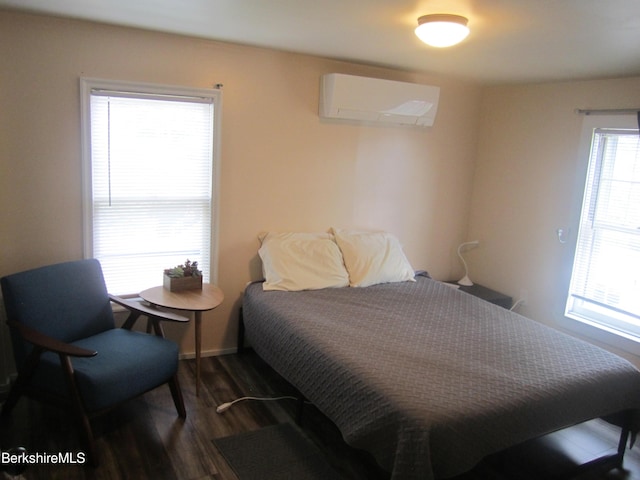 bedroom featuring dark hardwood / wood-style floors and a wall unit AC