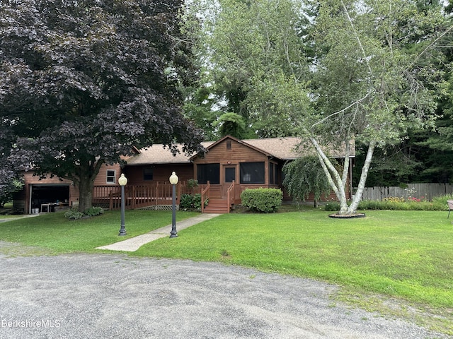 view of front of house with a sunroom and a front lawn