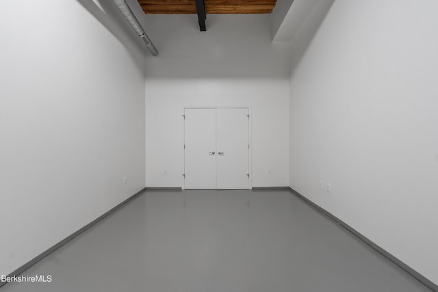 unfurnished room with beamed ceiling