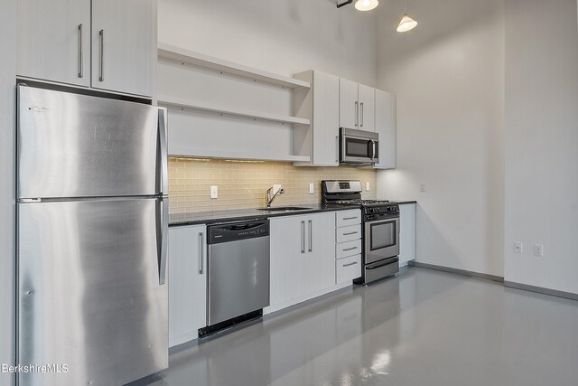 kitchen with backsplash, stainless steel appliances, white cabinetry, and sink