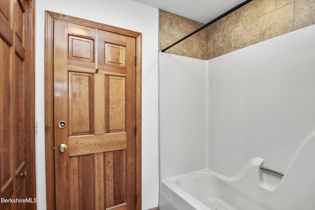 bathroom featuring a washtub and walk in shower