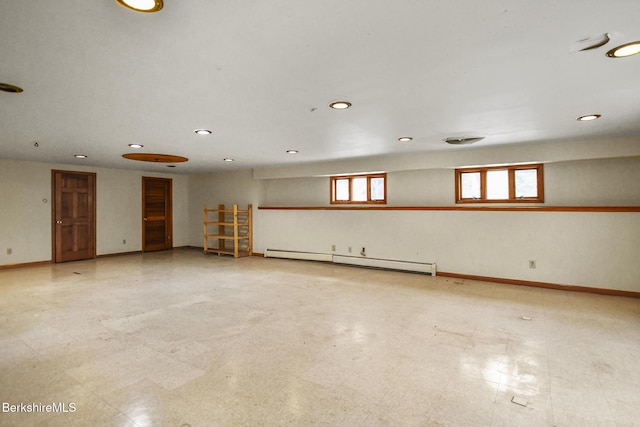 empty room with light floors, baseboard heating, and baseboards