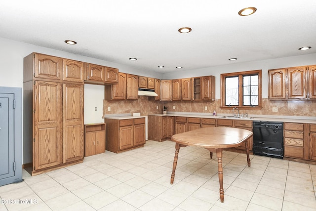 kitchen featuring under cabinet range hood, a sink, black dishwasher, brown cabinets, and tasteful backsplash