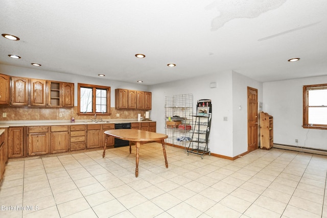 kitchen featuring a baseboard radiator, a sink, black dishwasher, brown cabinets, and tasteful backsplash