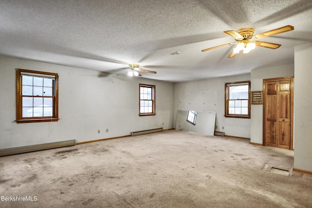 carpeted empty room featuring a textured ceiling, baseboard heating, a ceiling fan, and baseboards