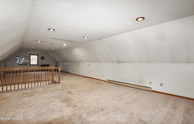 additional living space with lofted ceiling, a textured ceiling, a baseboard radiator, and carpet flooring