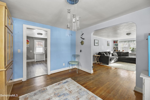 interior space featuring built in shelves, radiator heating unit, and dark wood-type flooring