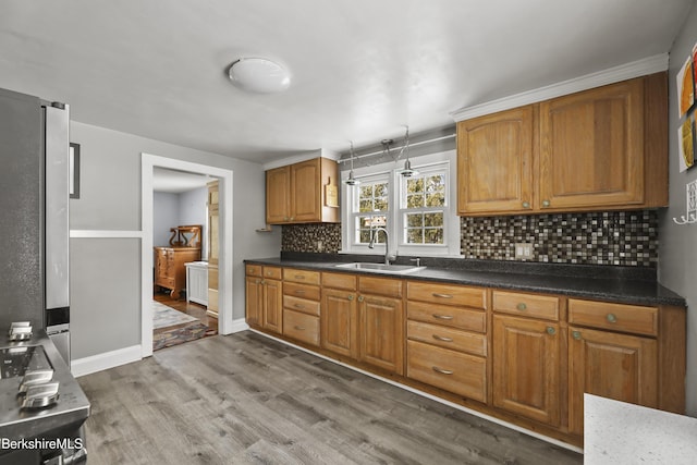 kitchen featuring hardwood / wood-style floors, stainless steel fridge, tasteful backsplash, and sink