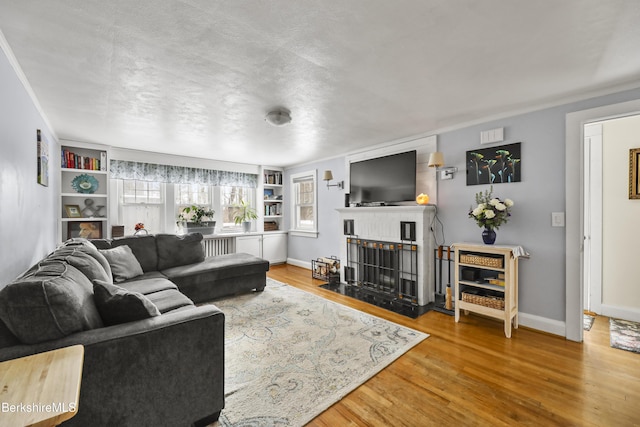 living room with built in shelves and hardwood / wood-style floors