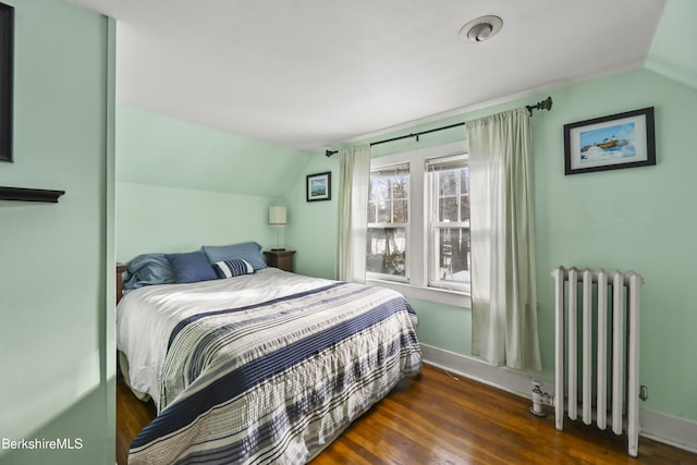 bedroom with lofted ceiling, radiator, and dark wood-type flooring