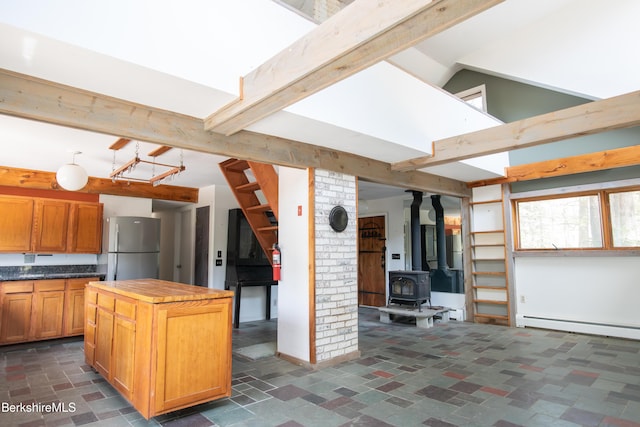 207-209 Main St, Becket, MA 01223 - kitchen with freestanding refrigerator, a wood stove, beam ceiling, a center island, and a baseboard radiator