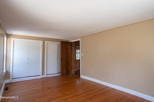 207-209 Main St, Becket, MA 01223 - unfurnished bedroom with visible vents, baseboards, multiple closets, and hardwood / wood-style flooring
