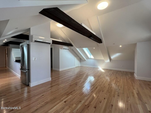 bonus room featuring vaulted ceiling with beams, an AC wall unit, and light hardwood / wood-style flooring