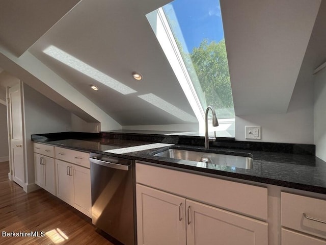 kitchen with white cabinetry, dishwasher, dark stone counters, and sink